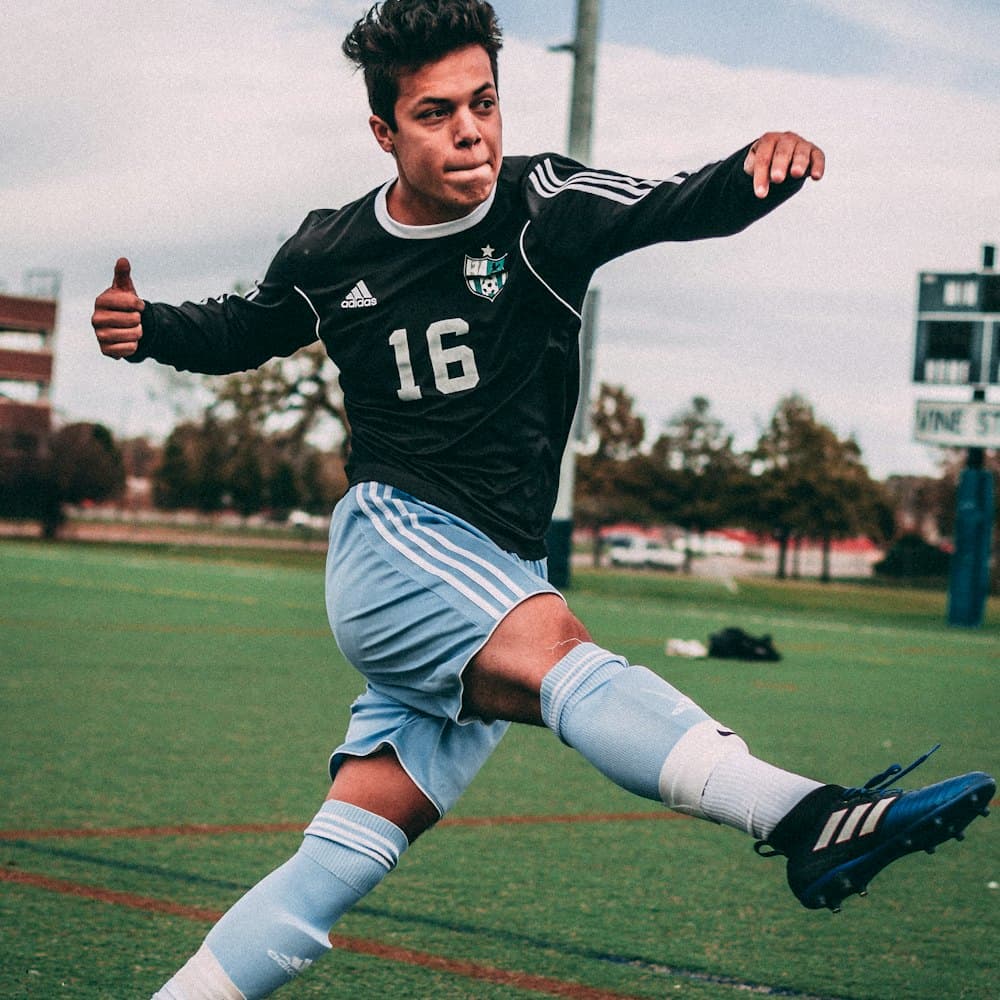 A young footballer striking the ball during a match