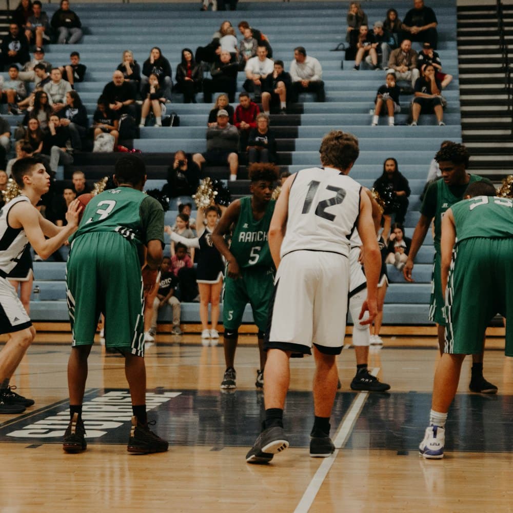An indoor basketball game in front of a crowd
